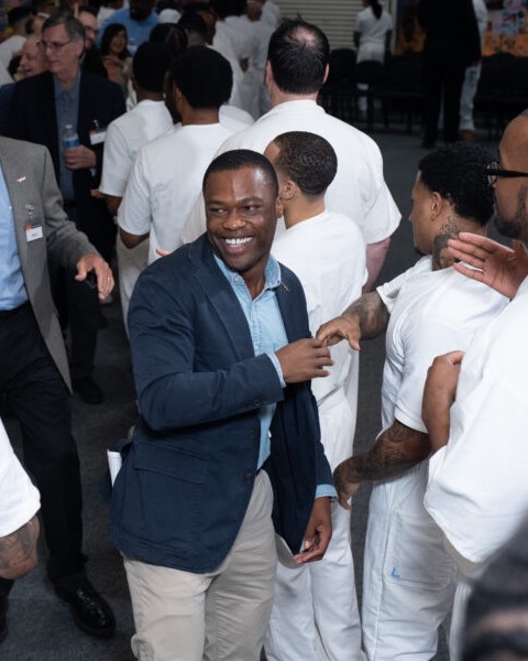 Charles J. Blain smiling while speaking with people at a gathering